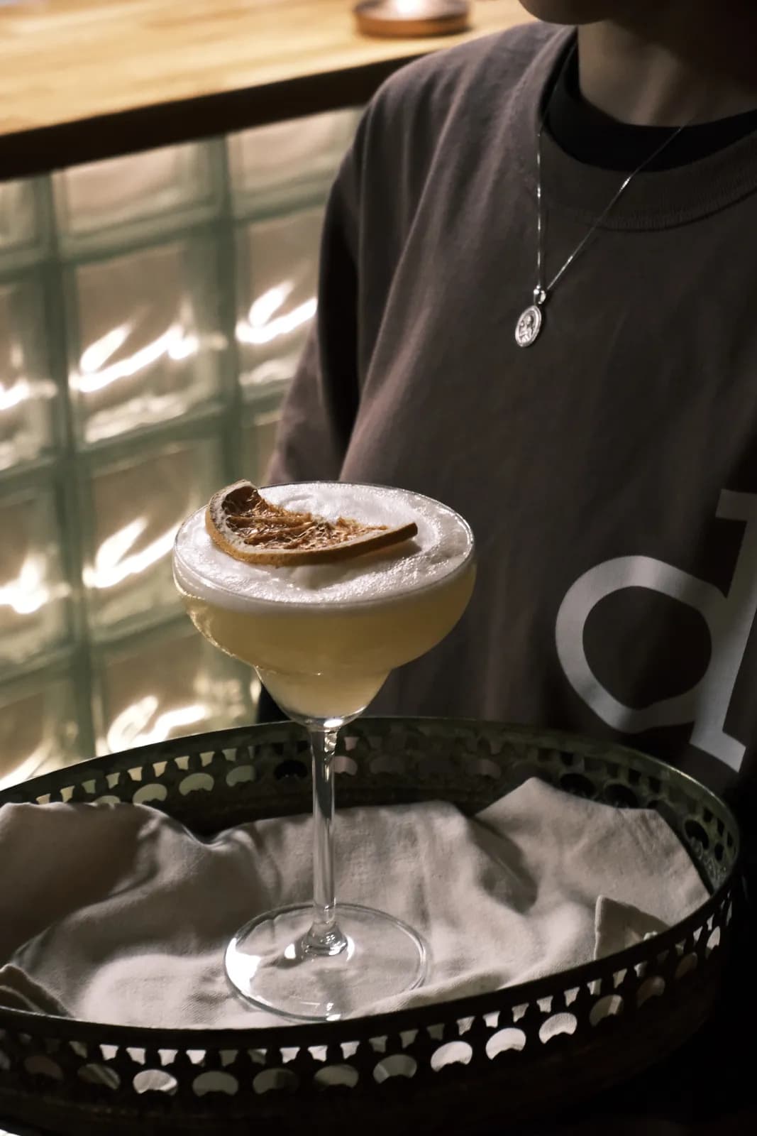 Barkeeper serviert einen Cocktail auf einem Tablett