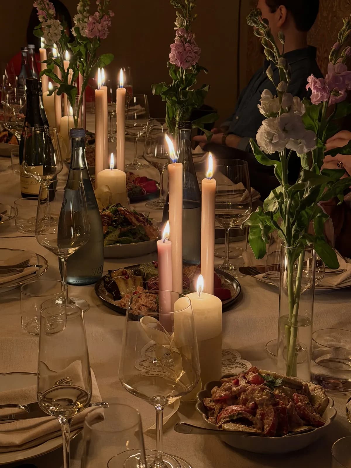 Kerzen und Blumen auf einer langen Tafel
